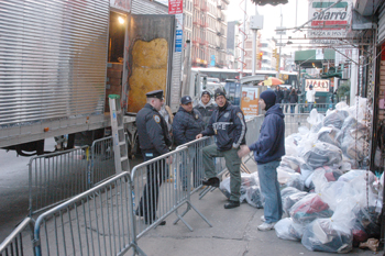 Police stand watch on Canal Street over dozens of evidence bags filled with imitation and counterfeit designer merchandise.