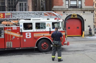 TOP: Ladder 8's firehouse on North Moore before it was chopped in half in 1914 to make way for the widening of Varick Street. Above: Firefighters back Ladder 8's truck into the North Moore firehouse. 