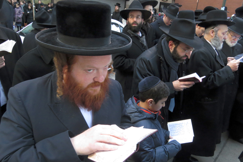 Men and their sons pray on Fulton Street, which like Water Street was a sea of black coats and hats. Photo: Carl Glassman/Tribeca Trib